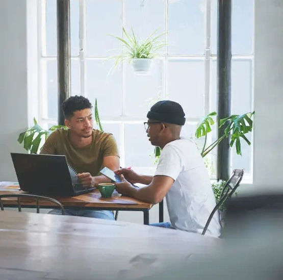 Two people sitting together in a bright room having a focused conversation